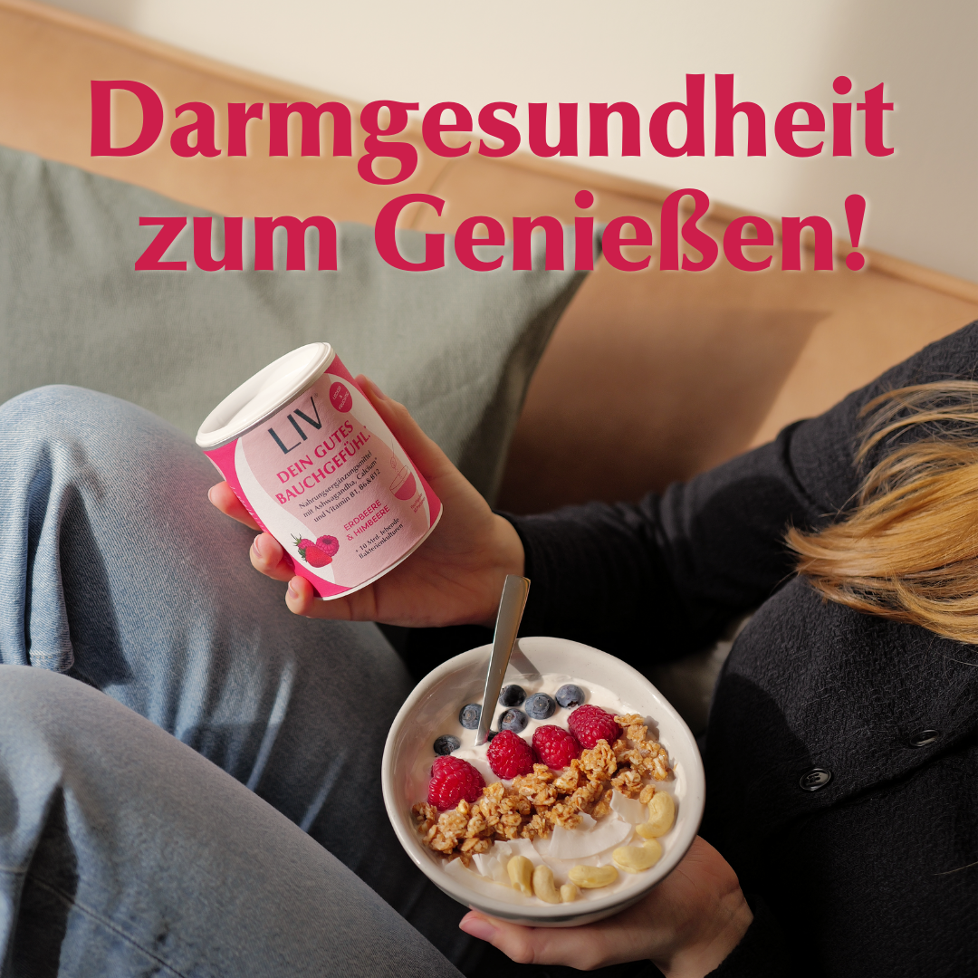 Frau sitzt auf Sofa, hält in einer Hand die Darmkur und in der anderen eine Bowl mit Früchten und Joghurt.